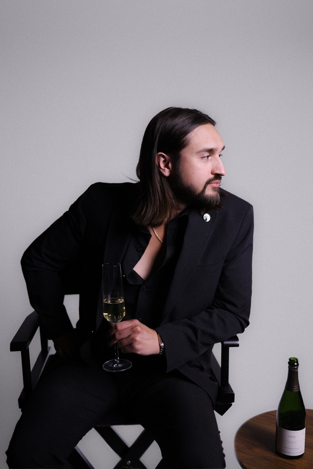 Nico Antuna Cooper, Certified Sommelier, holding a glass of Champagne